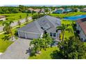 This gorgeous exterior elevation features an enormous roof, three-car garage, and lush landscaping with a lake view at 650 Rosemary Cir, Bradenton, FL 34212