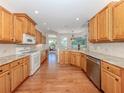 Kitchen with wood cabinets, stainless steel appliances, hardwood floors and granite countertops at 673 Crane Prairie Way, Osprey, FL 34229