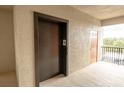 Hallway shot near an elevator with a glimpse of the building's exterior and natural light at 7005 River Hammock Dr # 303, Bradenton, FL 34212