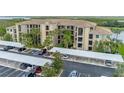 Exterior of condo building showcasing ample parking, covered spaces, and a tranquil lake view at 7005 River Hammock Dr # 303, Bradenton, FL 34212