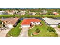 Beautiful aerial view of a well-kept home, showcasing a red tile roof, green lawn, and waterfront access at 74 Windsor Dr, Englewood, FL 34223