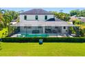 A sprawling backyard featuring a large, screened-in pool, green grass, and neatly trimmed shrubbery at 826 Honeyflower Loop, Bradenton, FL 34212