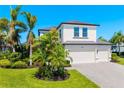 Beautiful two-story home with a three car garage, tropical landscaping, and a brick paver driveway at 826 Honeyflower Loop, Bradenton, FL 34212