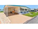 Home with carport, ramp and steps up to the front door, and manicured lawn at 830 Trento Dr, Venice, FL 34285