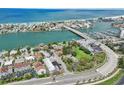 Aerial view showcases waterfront homes along the bay with a bridge leading to the beautiful ocean beach at 9300 Gulf Blvd, St Pete Beach, FL 33706