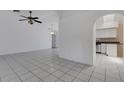 Open-concept living room with tile floors and arched entryway to the kitchen and dining area at 1026 Graham Rd, Venice, FL 34293
