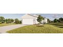 Well-maintained single-story home showcasing a two-car garage, lush greenery, and a meticulously kept lawn at 13046 Bayberry Way, Parrish, FL 34219