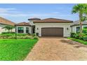 Charming home featuring a well-manicured lawn, brick driveway, and a two-car garage at 15315 Derna Ter, Bradenton, FL 34211