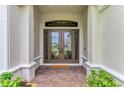 Elegant double front doors with decorative glass, framed by stately columns and a brick walkway at 15315 Derna Ter, Bradenton, FL 34211