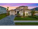 Two-story home boasting lush lawn, manicured landscaping, and charming curb appeal with a brick-paved driveway at 17128 Ranchside Pl, Lakewood Ranch, FL 34211