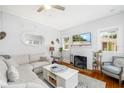 Bright living room with white brick fireplace, hardwood floors, and comfortable furnishings at 1871 Prospect St, Sarasota, FL 34239