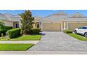 Inviting home featuring manicured landscaping, a paver driveway, and an attached two-car garage at 2070 Crystal Lake Trl, Bradenton, FL 34211