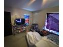 A cluttered bedroom with a TV, stained walls, and eclectic curtains at 2230 50Th N Ave, St Petersburg, FL 33714