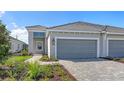 Charming home with a two-car garage, paver driveway, and vibrant, manicured landscaping at 2321 Blue Mahoe Ln, Sarasota, FL 34240