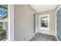 Cozy front porch with a tiled floor, light gray walls, and a blue front door at 2321 Blue Mahoe Ln, Sarasota, FL 34240