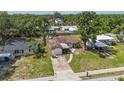 Overhead view of a compact home with front driveway and surrounding lush trees at 2558 Hawthorne St, Sarasota, FL 34239