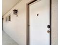 Condo front door featuring an exterior sconce light, windows, and the unit number displayed on the wall at 2763 Woodgate Ln # 211, Sarasota, FL 34231
