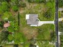 Bird's eye view of a home with a long driveway, lush green lawn and mature trees on a sunny day at 2912 51St E St, Bradenton, FL 34208