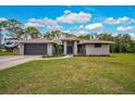 Charming one-story home boasts a well-manicured lawn, gray exterior, and an attached two-car garage at 2912 51St E St, Bradenton, FL 34208