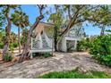 Charming two-story home with unique white railings surrounded by mature trees at 3737 Bayou Louise Ln, Sarasota, FL 34242