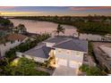 Beautiful waterfront home with a three-car garage, meticulously landscaped grounds, and stunning river views at sunset at 4 Winslow Pl, Longboat Key, FL 34228