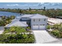 Elegant two-story home featuring a spacious three-car garage, complemented by lush landscaping and nearby waterfront at 4 Winslow Pl, Longboat Key, FL 34228