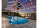 Gorgeous outdoor pool with a covered lanai, waterfront views, and a private dock, perfect for relaxing and entertaining at 4 Winslow Pl, Longboat Key, FL 34228