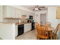 Cozy kitchen features white cabinets, tile backsplash, black appliances, and an adjacent dining area at 4165 66Th Street W Cir # H, Bradenton, FL 34209