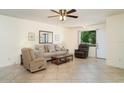 Inviting living room with tiled floors, neutral furniture, a ceiling fan, and natural light from a window at 4165 66Th Street W Cir # H, Bradenton, FL 34209