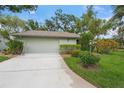 Charming home exterior with a well-manicured lawn, mature landscaping, and a two-car garage at 4637 Willow Wood Cir # 44, Sarasota, FL 34241