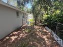 A view of the backyard featuring a chainlink fence, side of house and small window at 4740 Garcia Ave, Sarasota, FL 34233