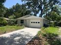 Inviting single-story home with a driveway, one-car garage and mature tree shading the front at 4740 Garcia Ave, Sarasota, FL 34233