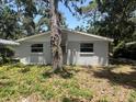 Exterior rear of home with white painted windows and central air unit surrounded by a tree at 4740 Garcia Ave, Sarasota, FL 34233