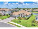 Stunning exterior view of a single-Gathering home featuring a tile roof, three-car garage and well-manicured landscaping at 4925 Coastal Days Ln, Bradenton, FL 34211