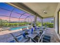 Inviting screened-in patio featuring an outdoor dining area, overlooking the pool and lush backyard at 4925 Coastal Days Ln, Bradenton, FL 34211