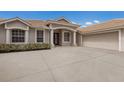 Close-up view of the front entrance and two-car garage of the home featuring a large driveway at 4998 Cedar Oak Way, Sarasota, FL 34233