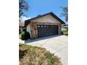 Oversized garage featuring a stone facade and a concrete driveway, perfect for multiple vehicles at 5213 20Th Street E Ct, Bradenton, FL 34203