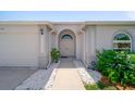 Inviting home entrance with arched doorway, manicured landscaping, and a neutral color scheme at 5410 Matthew Ct, Sarasota, FL 34231