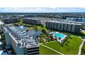 Aerial view of a condo community with a swimming pool, lake, and well-maintained grounds at 5750 Midnight Pass Rd # 203, Sarasota, FL 34242