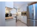 Bright kitchenette featuring granite counters, white cabinets, and modern stainless-steel appliances at 5750 Midnight Pass Rd # 203, Sarasota, FL 34242