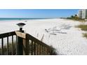 Beautiful beach with white sand and clear water featuring rows of beach chairs at 5880 Midnight Pass Rd # 202, Sarasota, FL 34242