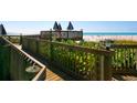 Wooden walkway with lush greenery leads to a tranquil beach with lounge chairs at 5880 Midnight Pass Rd # 202, Sarasota, FL 34242