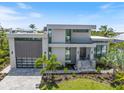 Modern home exterior with stone accents, well-manicured landscaping, and an attached garage at 590 De Narvaez Dr, Longboat Key, FL 34228