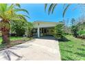 Inviting single-story home with a carport, screened porch and tropical landscaping at 681 Fox St, Longboat Key, FL 34228
