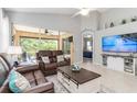 Bright living room with high ceilings, sliding glass doors, leather furniture, and a neutral color palette at 7343 Birds Eye Ter, Bradenton, FL 34203