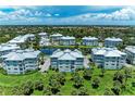 Aerial view of condo complex with a serene pond, surrounded by lush greenery and multiple residential buildings at 7820 34Th W Ave # 102, Bradenton, FL 34209