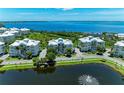 Scenic aerial view of waterfront condos overlooking a tranquil lake with a fountain, showcasing a picturesque community at 7820 34Th W Ave # 102, Bradenton, FL 34209