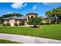 Beautiful single-story home boasting lush front lawn, mature landscaping, and charming, covered entryway at 8312 Misty Lake Cir, Sarasota, FL 34241