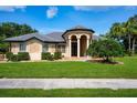 Beautiful single-story home featuring a manicured lawn and a welcoming, covered entranceway with stately pillars at 8312 Misty Lake Cir, Sarasota, FL 34241