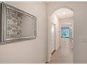 Bright hallway features tiled floors, an arched entryway, and a decorative mirror at 8557 Milestone Dr, Sarasota, FL 34238